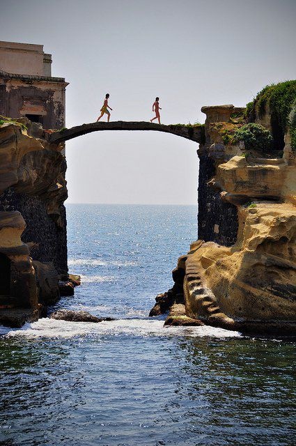 People Crossing Bridge Between Cliffs